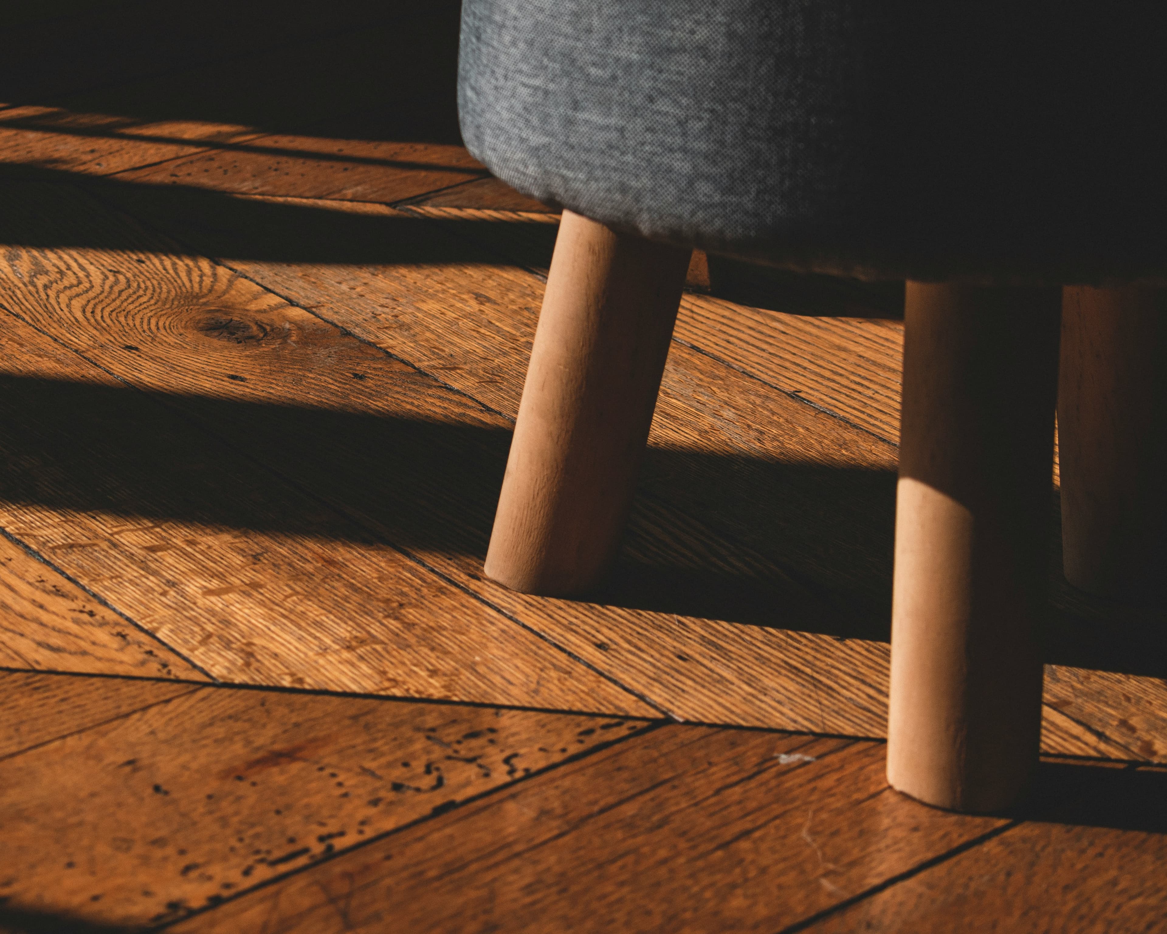 Close-up of a wooden stool on oak parquet flooring