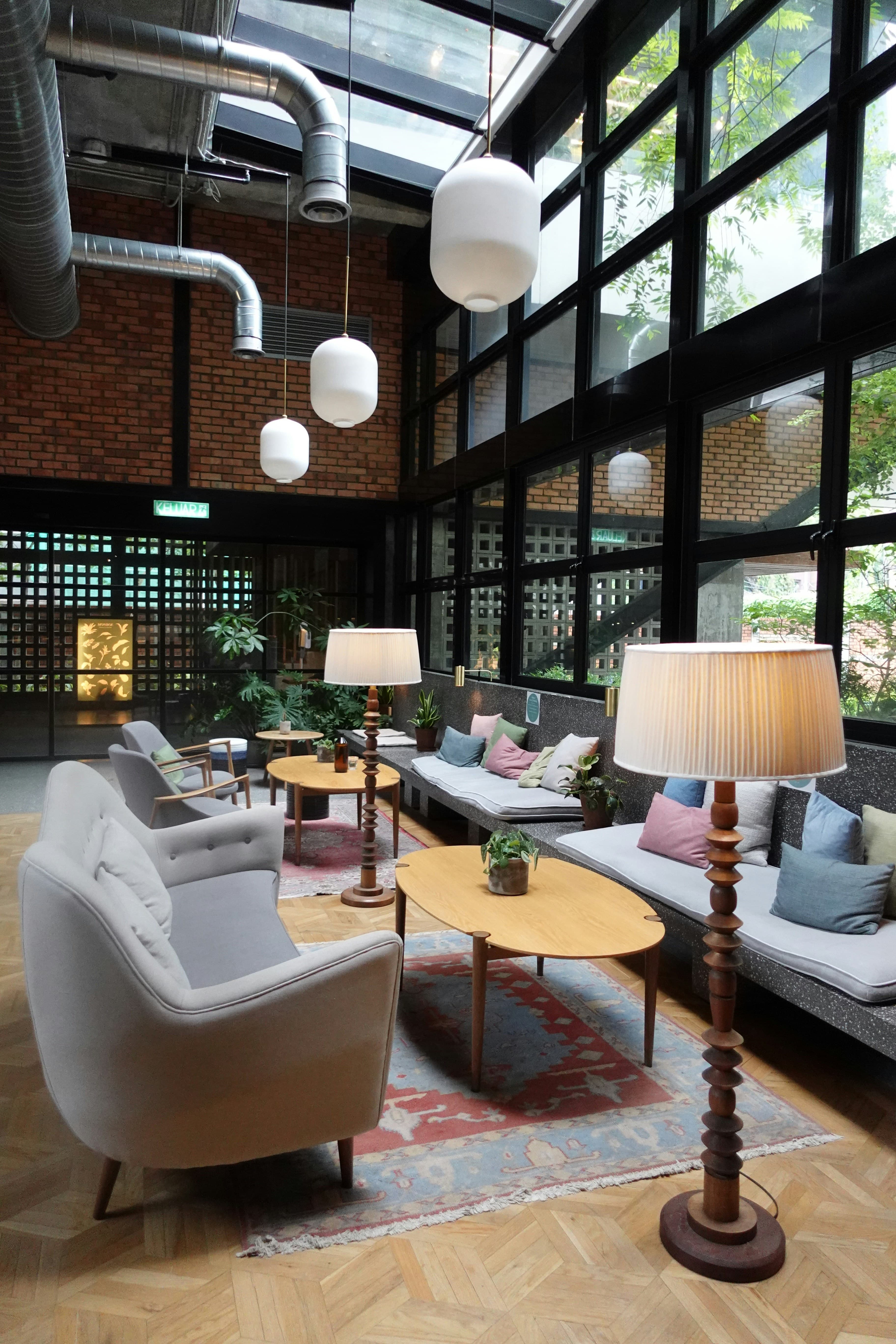 Hotel lounge with armchairs, sofas, wooden tables and floor lamps