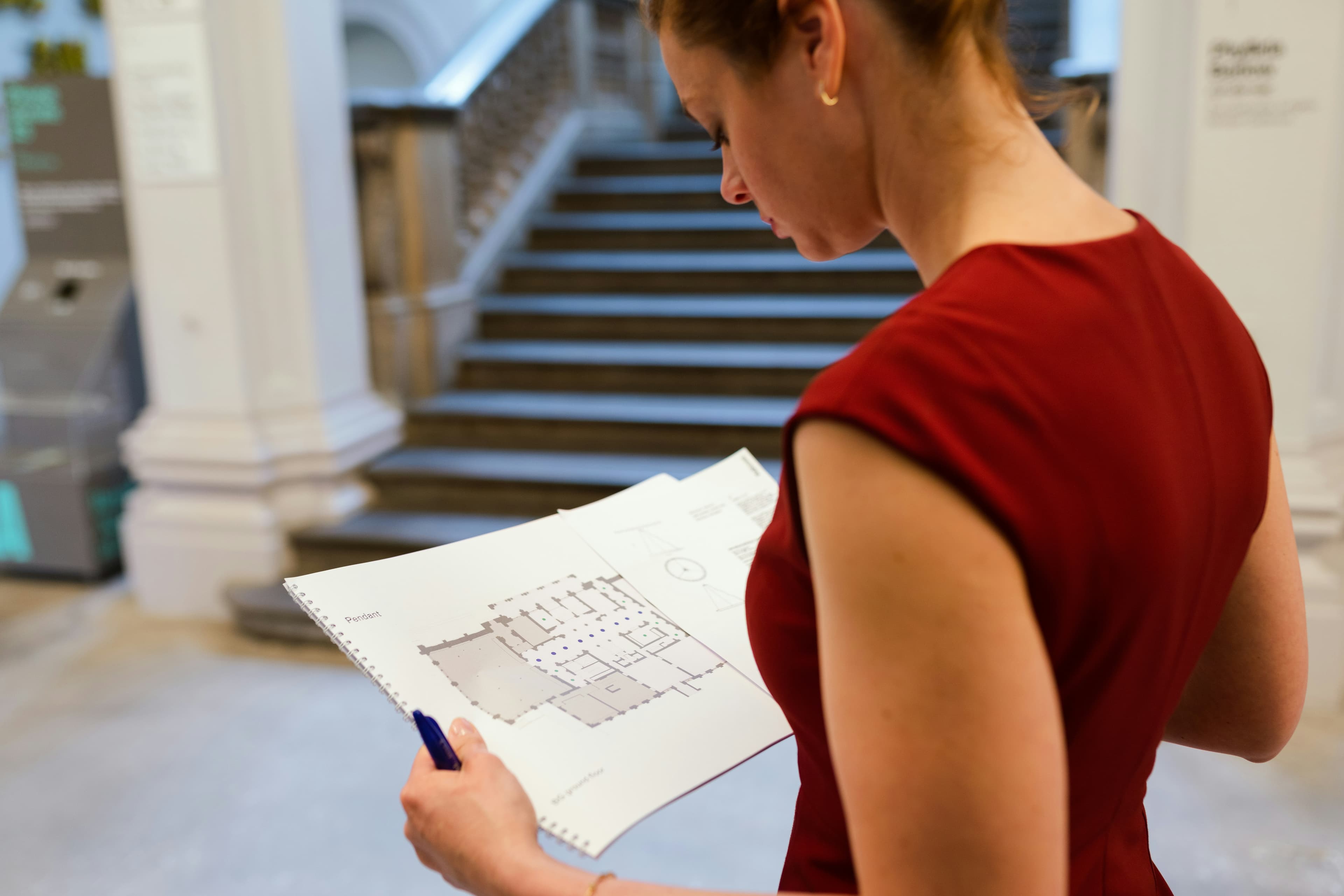 Surveyor reviewing a building floor plan during a property inspection